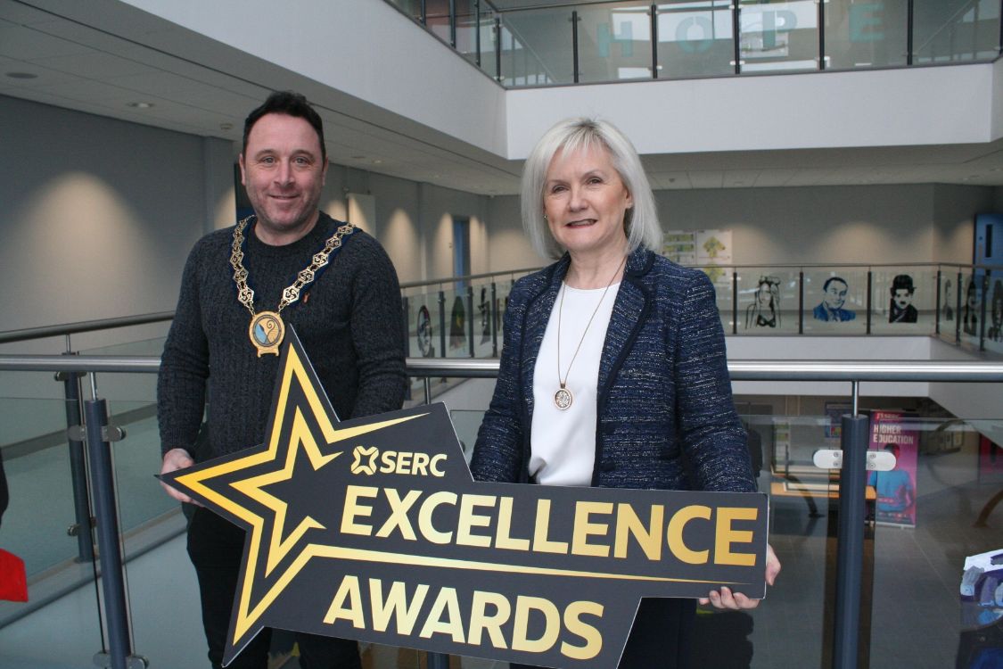 Chair of Newry Mourne and Down District Council Peter Byrne and Heather McKee, SERC's Deputy Principal, Planning, Performance & Engagement at the Downpatrick Campus holding the Excellence Awards sign